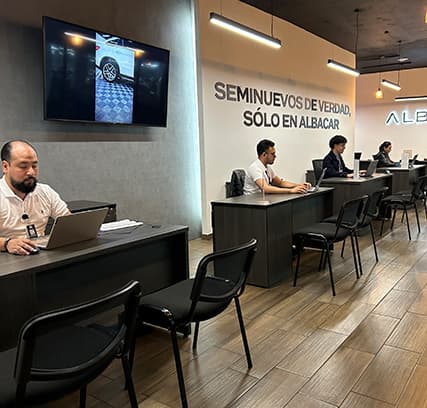 Asesores de Albacar atendiendo a clientes en el piso de ventas